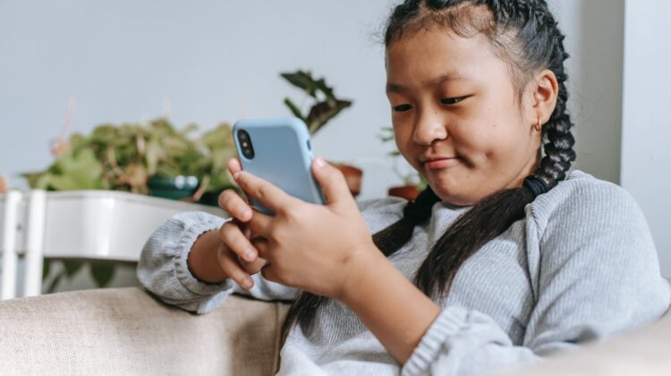 concentrated asian girl looking at smartphone