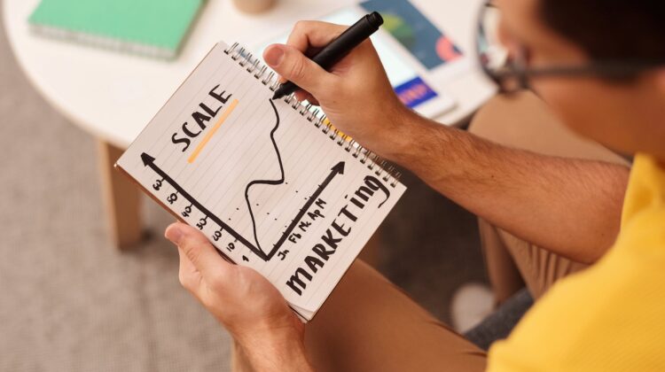 man drawing a graph on notebook